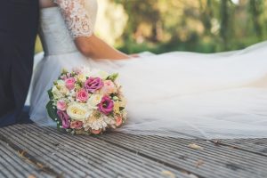 Foto einer sitzenden Braut mit Blumenstrauß